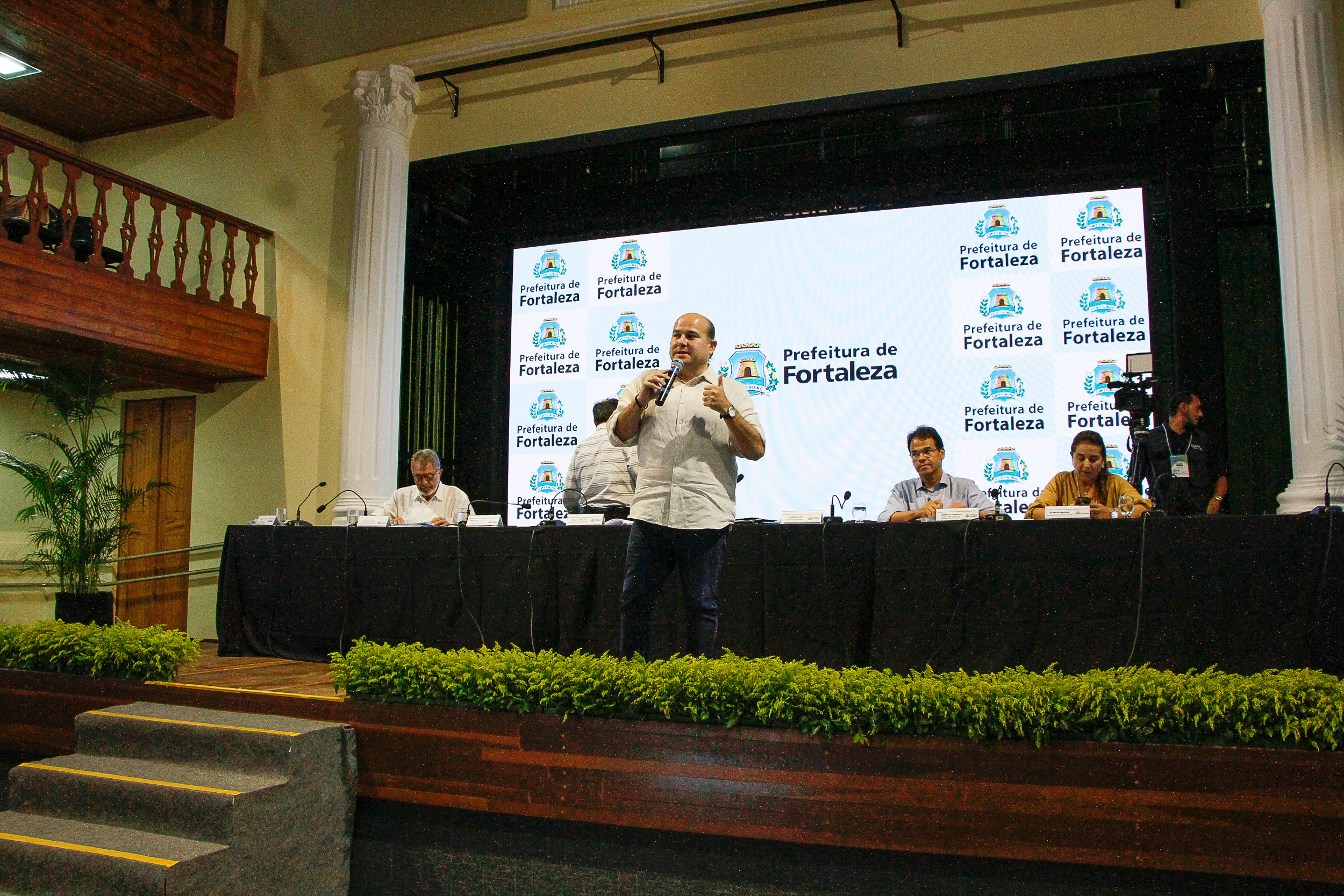 prefeito roberto cláudio discursa em um palco